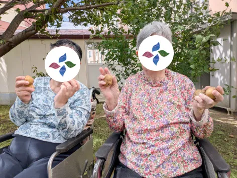 グループホーム朝風 庭で実った果実を手にする入居者のみなさん